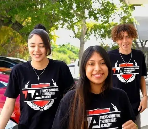Three students smiling outside school